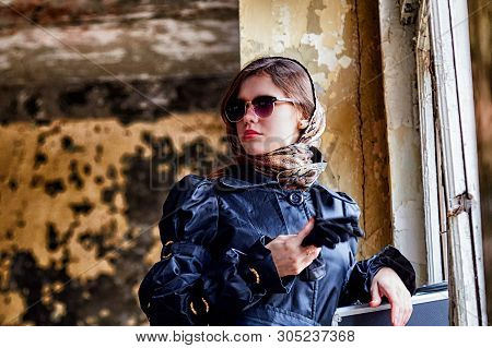 Girl In A Black Cloak, A Scarf And A Diplomat In An Abandoned House Near Window. A Spy In A Secret M