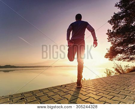 Man Runner Doing Stretching Exercise, Preparing For Morning Workout In The Lake Park. Street Fitness