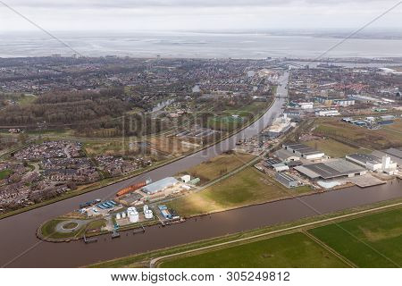 Aerial View Dutch Residential Area Delfzijl With Channel Eemskanaal And Industrial Park Near Harbor