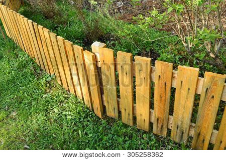 Brown Wooden Fence In Garden Green Background With Parallel Plank Old