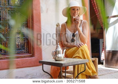 Elegant woman dirnking mint tea in Moroccan riad