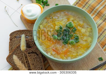 Traditional Soup Of Russia Shchi With Green Onion Served With Sour Cream As Garnish And Rye Bread