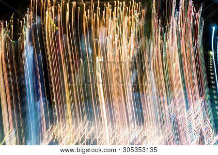 Abstract Of Multicolored Lights Stripes Moving Fast In Dark Background. Orange Violet And Bluel Back