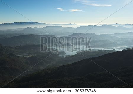 Fresh Foggy Mountain Landscape On Sunrise. View To Valley With The Maskeliya Reservoir Adam's Peak (