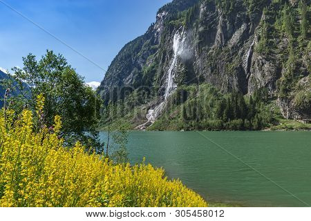 Idyllic Mountain Landscape In The Alps With Blooming Flowers, Mountain Lake And Waterfall. Stillup, 