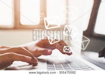 Email Marketing And Newsletter Concept. Hand Of Man Sending Message And Laptop With E-mail Icon