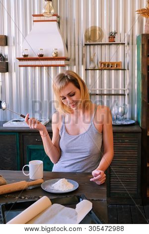 A Beautiful Freckled Blonde Girl In Pajamas Is Standing Near The Kitchen Table, Drinking Fock, Tea A