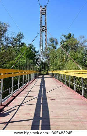 Mountain Suspension Bridge With Yellow Railings On The Mountain Kizilovka In The Foothills Of The No