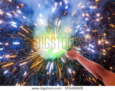 Hand Charki, A Hand Firework Emitting Circular Sparks In Black Background
