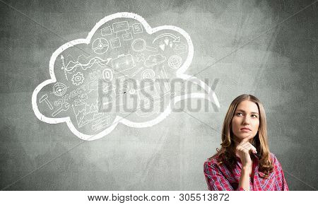 Serious Woman Looks Pensive Upwards And Thinking Something. Speech Bubble Full Of Business Diagrams 