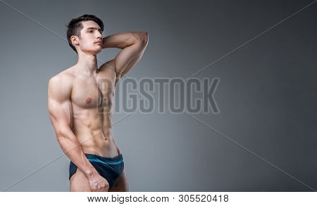 Young Male Athlete Bodybuilder Posing. Handsome Athletic Male Power Guy. Fitness Muscular Person. Yo