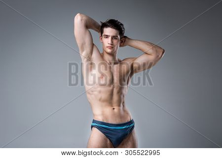 Young Male Athlete Bodybuilder Posing. Handsome Athletic Male Power Guy. Fitness Muscular Person. Yo