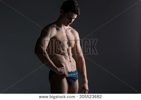 Young Male Athlete Bodybuilder Posing. Handsome Athletic Male Power Guy. Fitness Muscular Person. Yo