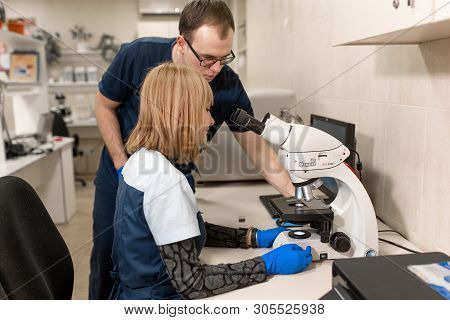 Dnepr/ukraine - 03.14.2019: Laboratory Assistants Analyze Sample Looking Through Microscope. Make Re
