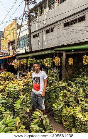 Makassar, Sulawesi, Indonesia - February 28, 2019: Terong Street Market. Banana Vendor In White, Red