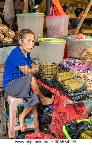 Makassar, Sulawesi, Indonesia - February 28, 2019: Terong Street Market. Woman With Blue Shirt Sits 