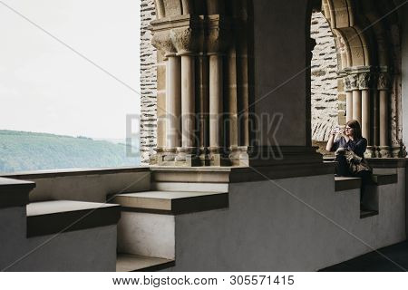 Vianden, Luxembourg - May 18, 2019: Woman Taking Pictures On Mobile Phone From Vianden Castle, Luxem