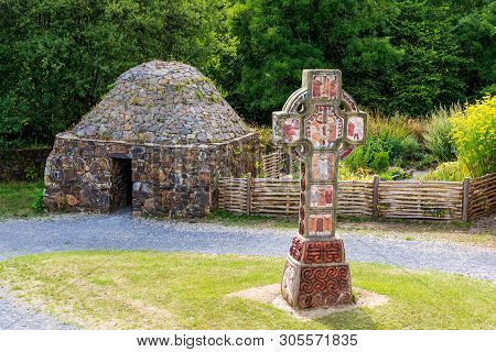 Ancient Stone Cottage With Celtic Cross In Centre, Concept Of Early Age Human Settlement, Green Fore