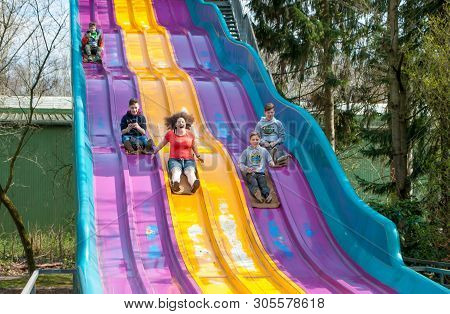 Hodenhagen, Germany, March 30, 2019: Children Rolling Down The Hill In The Amusement Park