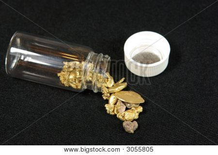 Versato bottiglia di pepite d'oro