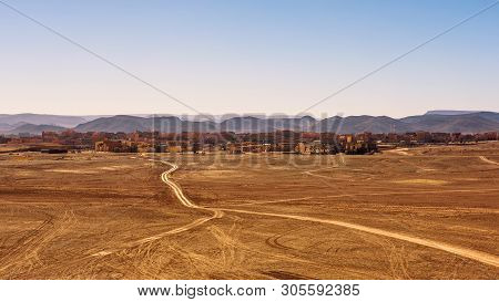 Dirt Road Going To The City Of Ouarzazate In Morocco. Ouarzazate With Typical Moroccan Architecture 