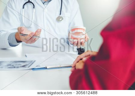 Dentist Talking To Male Patient And Presenting Results On Dental X-ray Film About The Problem Of The