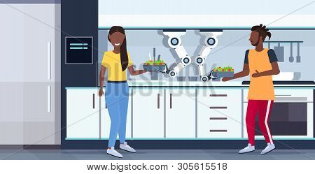 Smart Handy Chef Robot Cooking And Serving Fresh Salad To African American Couple Kitchen Assistant 