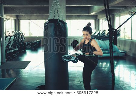 Female Sporty Boxer is Exercised Training Punching in Fitness Club,Portrait of Boxing Woman is Practicing Footwork With Boxing Bag.,Beautiful of Asian Girl Doing Exercising in Gym. Sport Lifestyles.