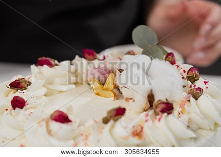 The Condater Sprinkles The Cake With Grated Almonds And Coconut. Close-up Of A Hand And Pouring Crum