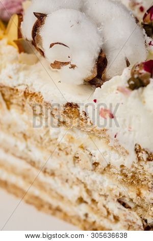 Half A Cake. Close-up Of A Cut Cake With Visible Layers And Filling. Onditer Holds The Cake In His H
