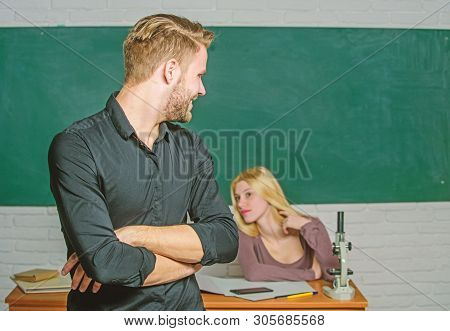 Confident In His Knowledge. Handsome Man Standing Hands Crossed In Classroom With Teacher. Male Stud