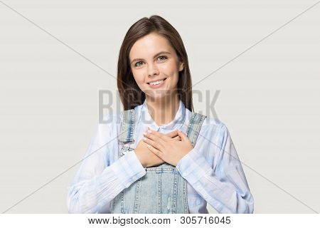 Attractive Young Woman Holding Hand On Heart Feels Gratitude