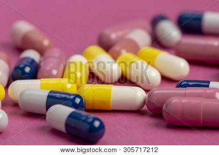 Medical Pills Yellow, Blue And Red On A Colored Background