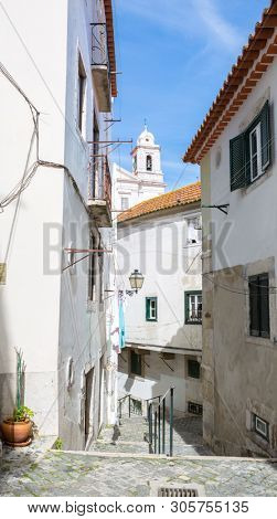 Typical narrow winding street in the Alfama district, Lisbon, Portugal.