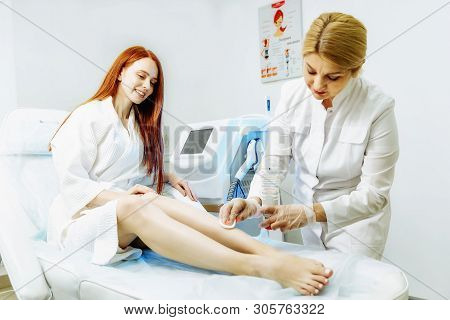 Women Removed The Remains Of Wax After A Legs Laser Epilation
