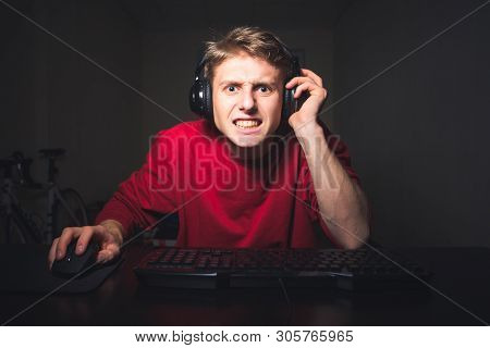 Portrait Of An Emotional Guy Playing Video Games On A Computer, Concentrated Face Looking Into The C
