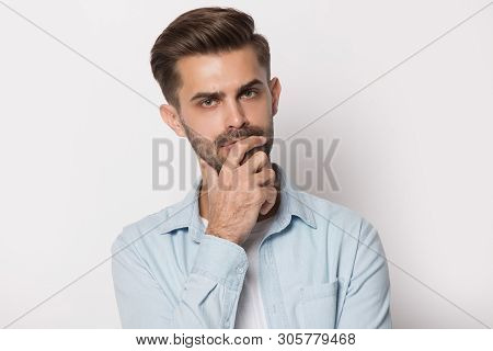 Thoughtful Young Man Holding Hand On Chin Feeling Doubtful
