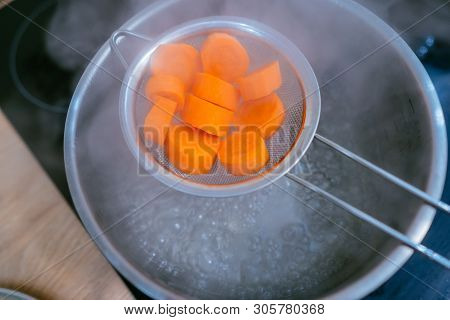 The Image Of A Small Amount Of Chopped Carrots Over A Boiling Pan