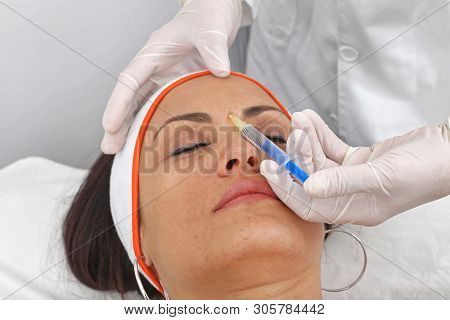 Young Woman Having Fillers Injection In Glabella Between Eyebrows