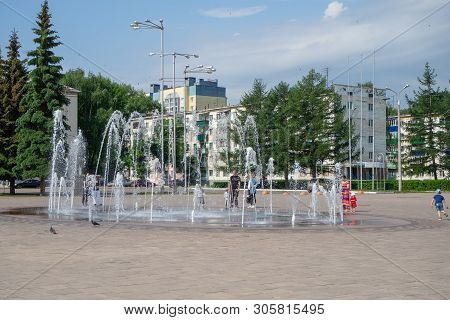 Sterlitamak, Russia - June 1, 2019; People Stand Near The Fountain In The Town Square.