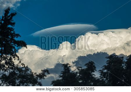 Rare Lenticular Cloud Altocumulus Lenticularis On Top Of A Cumulus Cloud In Front Of A Blue Sky