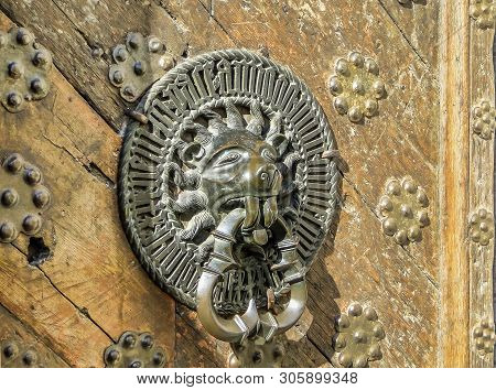 Carved Door Handle Shaped As Lion On Old Wooden Door