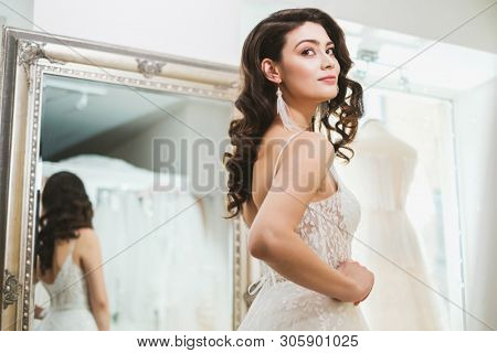 Beautifu bride choosing wedding dress in a wedding salon