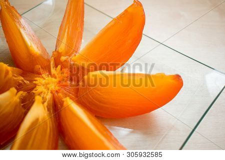 Тhe Persimmon Is Cut Into Slices On A Plate