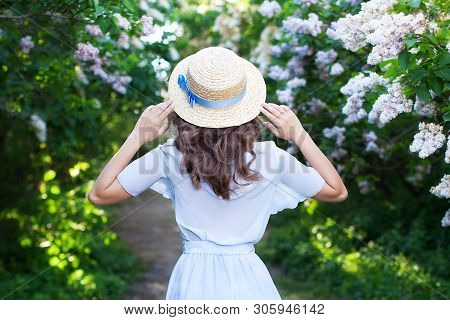 Girl In A Straw Hat With A Blue Ribbon On A Spring Afternoon. Back View. Trendy Casual Summer Or Spr