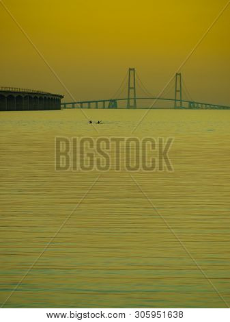 The Bridge Across The Great Belt - The Storebaelt Bridge In Denmark. Two Canoes On Water Surface. Su