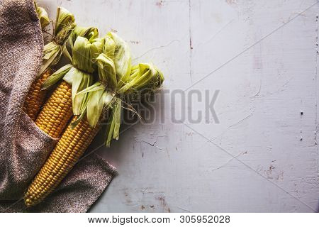 Raw Corns Freshly Picked With Green Cornhusk On Rustic Table Vintage Background Top View A