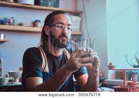 Diligent Entusiastic Master In Glasses At His  Pottery Studio Is Workig For A New Dish.