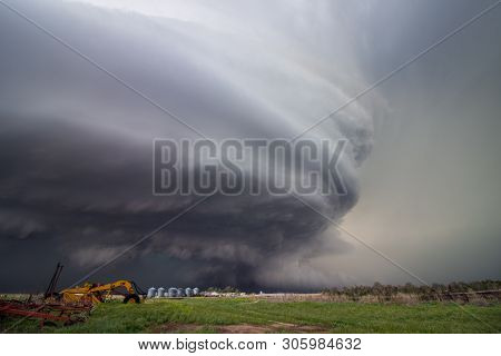 A Huge Supercell Storm With A Ground Scraping Wall Cloud Fills The Sky Over Nebraska Farmland. Stria