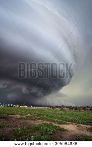 A Huge Supercell Storm With A Ground Scraping Wall Cloud Fills The Sky Over Nebraska Farmland. Stria